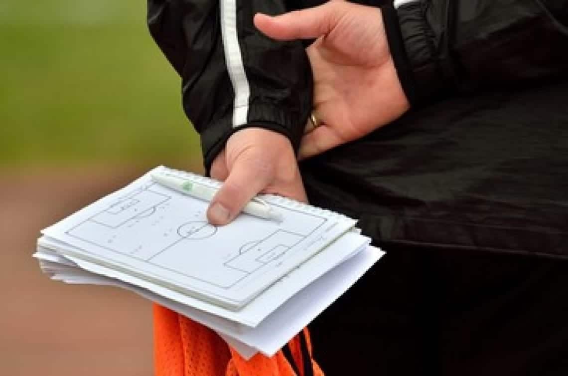 Hand holding soccer strategy notes